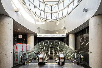 Escalators in a metro station with a glass dome in Warsaw.
