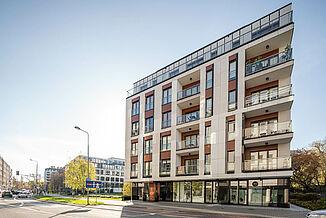 Street view of the Piano House residential building with many balconies and windows in Warsaw.