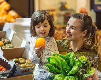 A woman and a child buy fruit and vegetables in the supermarket.