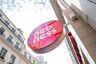 Illuminated sign from the neoness fitness studio on a residential and commercial building in Paris.