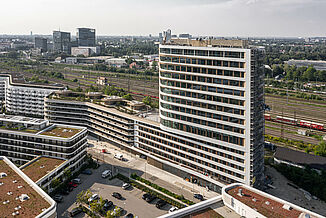 NEO residential quarter with roof terrace and railway infrastructure in the background.