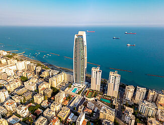 Aerial view of Limassol with the luxury residential tower ONE directly on the beach.
