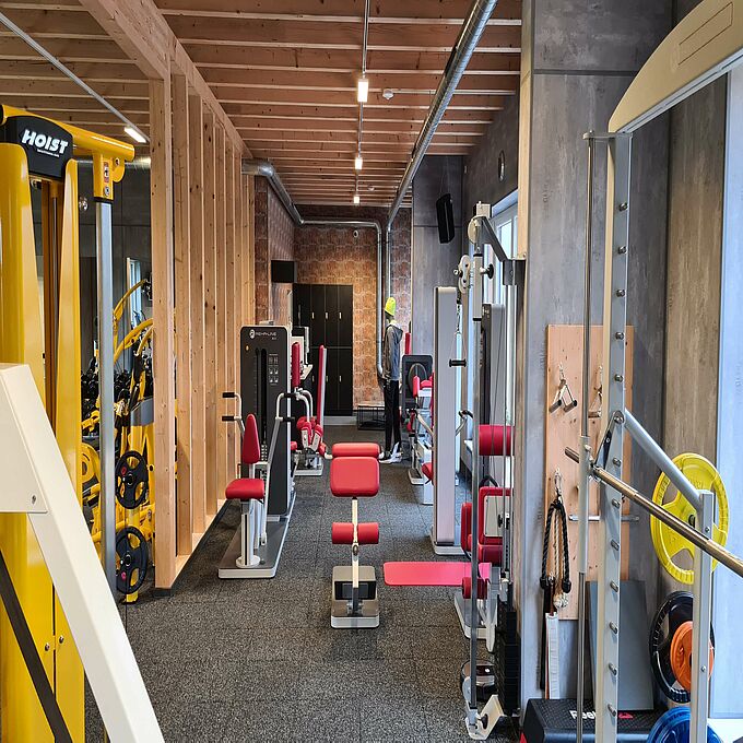 Interior view of the RhönFit therapy centre in Dermbach with various fitness equipment on a REGUPOL gym floor.