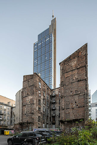 In the foreground is a ruined building and behind it you can see the Varso Tower in Warsaw.