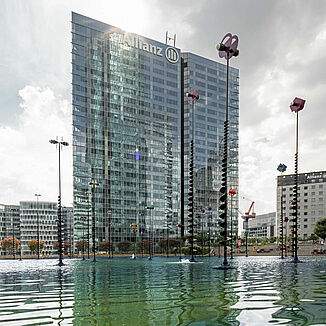 The La Défense office district in Paris with the Allianz One Tower and a pond in front of it.