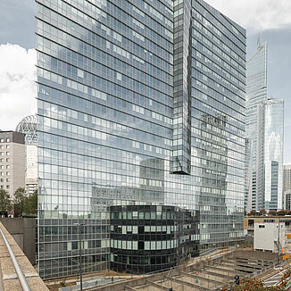 The Allianz One Tower in Paris with other residential and commercial buildings in the background.