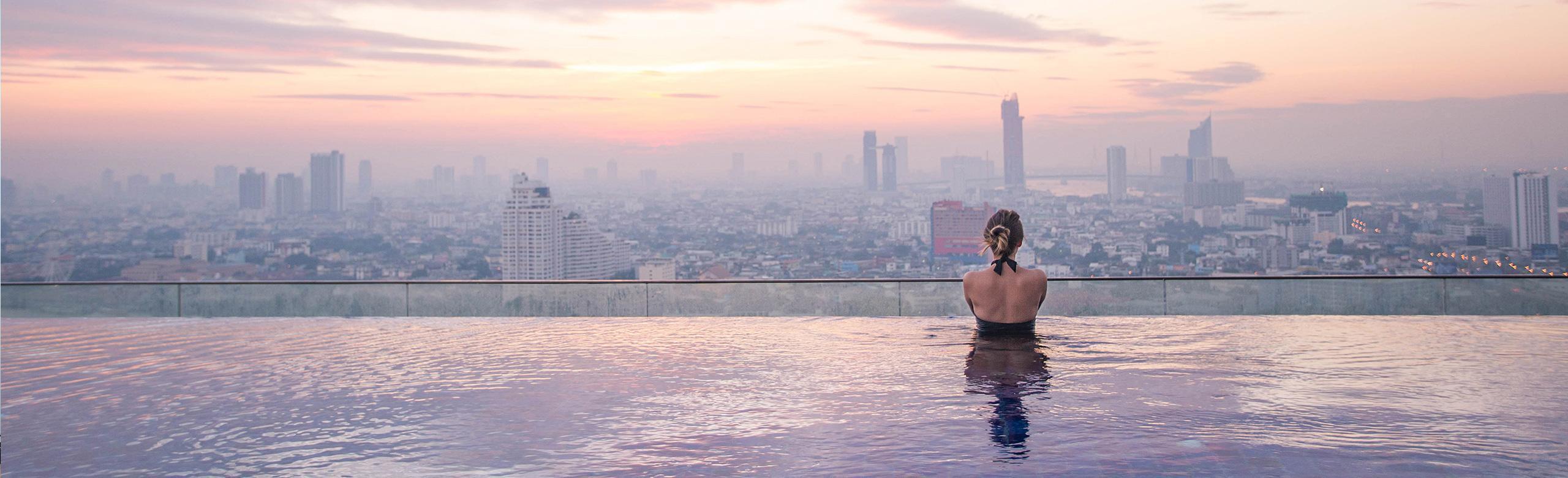 pool vibration isolation A woman stands in an infinity pool and looks at the city skyline.