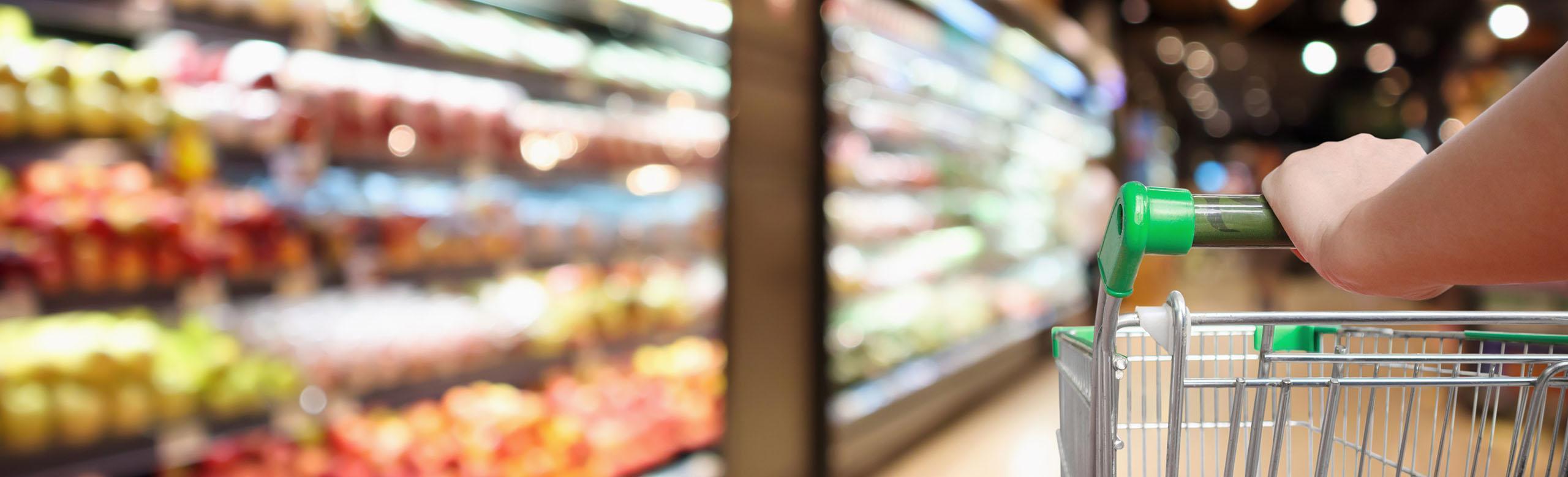 A shopping trolley is wheeled through the aisles of a supermarket.